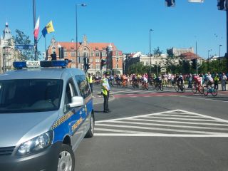 strażnicy miejscy zabezpieczaja wyścig kolarski