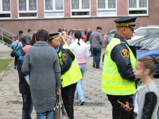 Strażnicy miejscy rozdają dzieciom odblaski