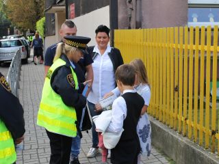 Strażnicy miejscy rozdają dzieciom odblaski