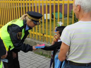 Strażnicy miejscy rozdają dzieciom odblaski