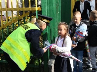 Strażnicy miejscy rozdają dzieciom odblaski