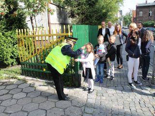 Strażnicy miejscy rozdają dzieciom odblaski