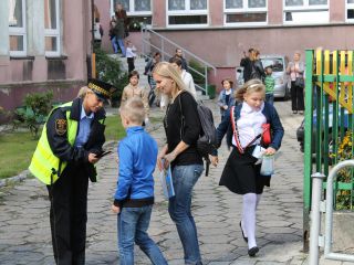 Strażnicy miejscy rozdają dzieciom odblaski