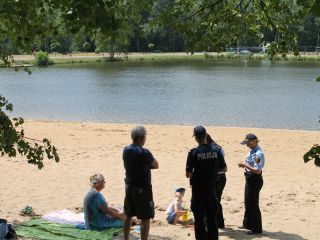 Strażniczki miejskie i policjant podczas akcji profilaktycznej na kąpielisku Trzy Stawy w Katowicach