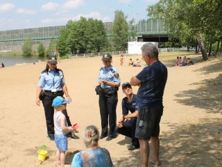 Strażniczki miejskie i policjant podczas akcji profilaktycznej na kąpielisku Trzy Stawy w Katowicach